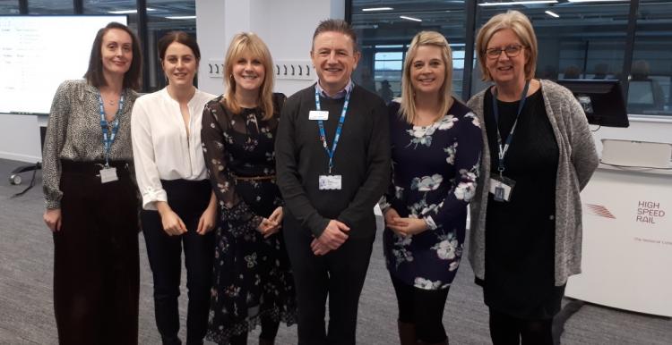 A group of people stood up smiling at the camera