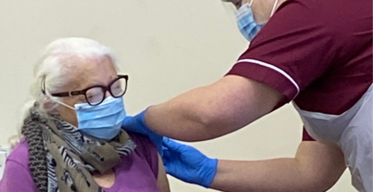 An elderly woman receiving an injection