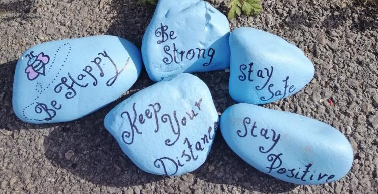 Blue coloured rocks with messages of positivity written on them
