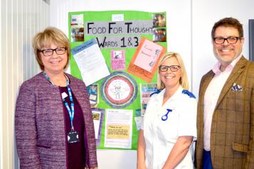 A group of people stood up smiling at the camera