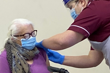 An elderly woman receiving an injection