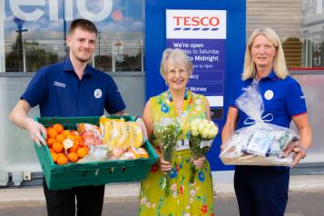 Maureen collecting the first donation of flowers and fruit from store colleagues Micky and Nicola.