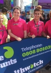 Four females stood in front of a banner that says Healthwatch Doncaster