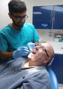 Patient sitting in dentist chair with dental treatment taking place