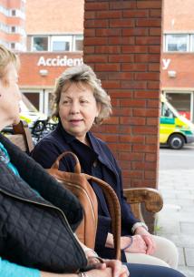 Two women sat down outside a hospital